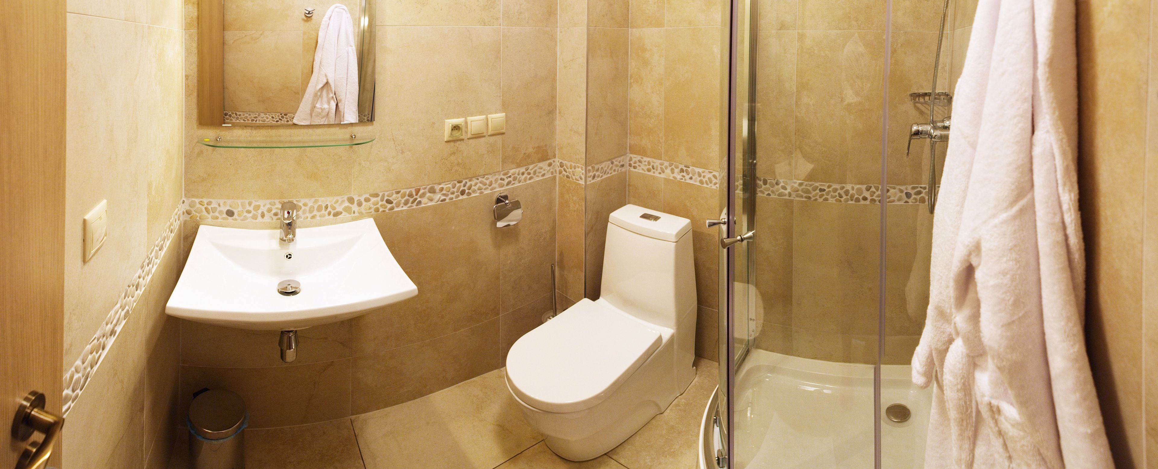 Une salle de bain équipée d’un lavabo, de toilettes et d’une douche à parois de verre.