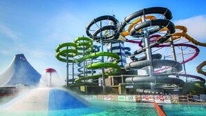 Un parco acquatico con diverse scivolate e una grande fontana d'acqua.