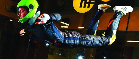 A person in a helmet and protective suit performing a stunt.