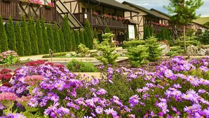 Un edificio in stile chalet tradizionale, con facciata in legno e un balcone decorato con fiori.