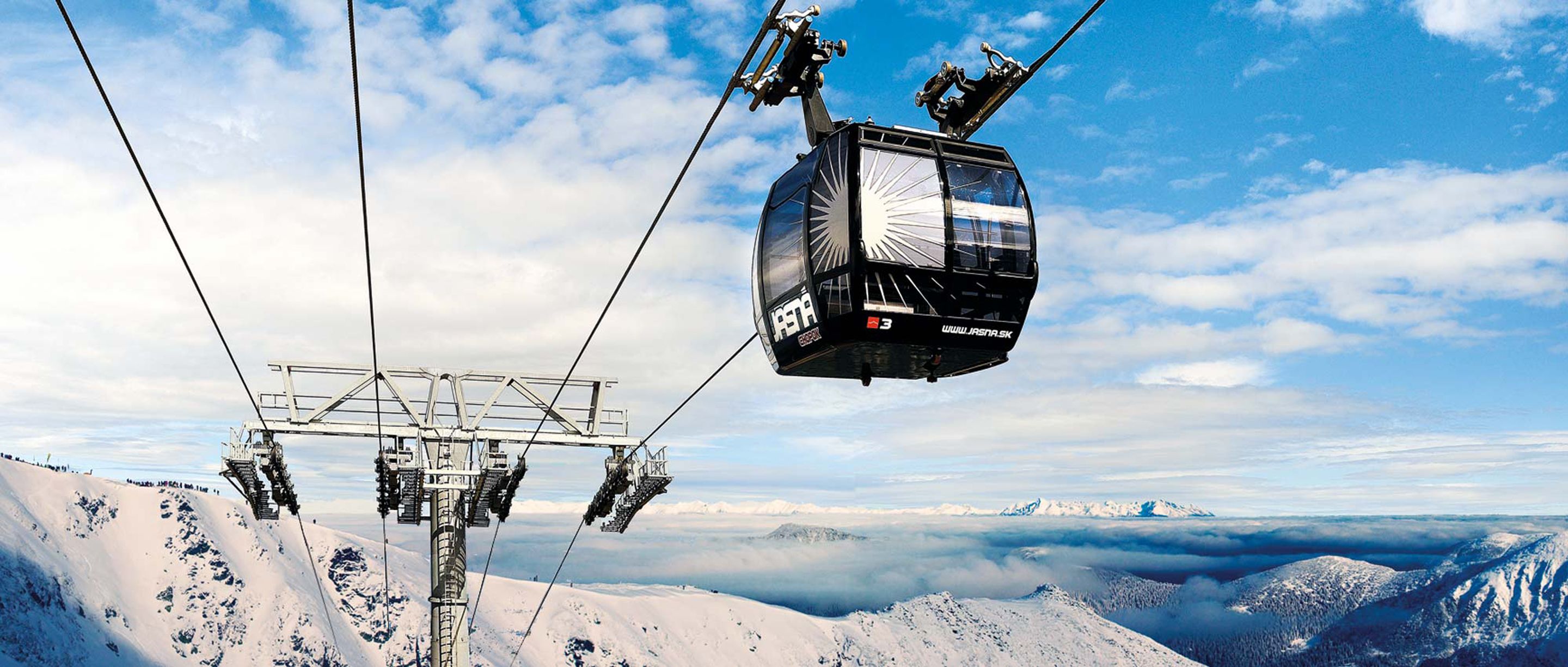 A cable car system with a clear view of the surrounding snowy mountain landscape.