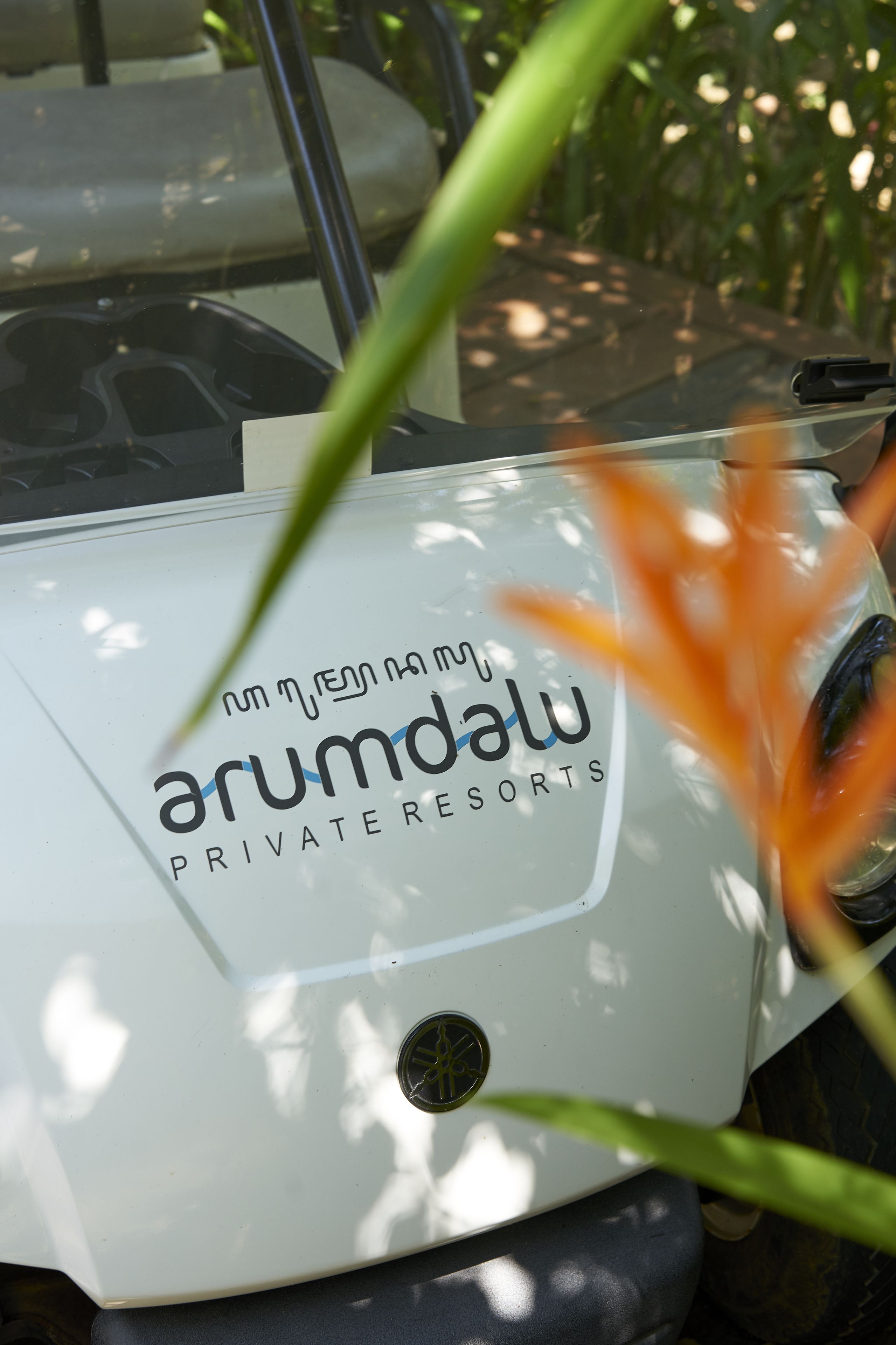 Un golf cart bianco con il marchio 'Arundalu Private Resorts'.