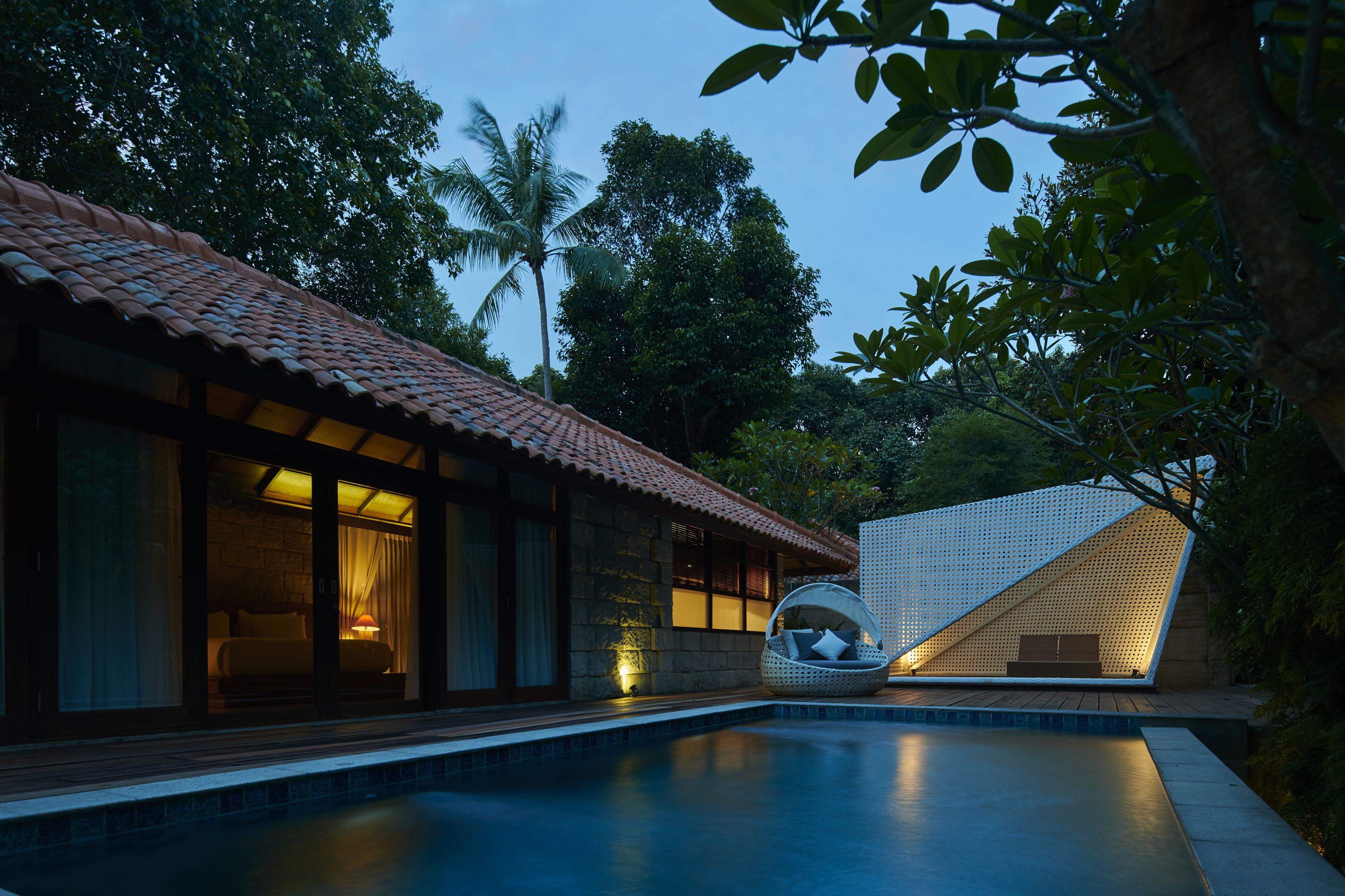 A modern villa with a swimming pool, a cozy bedroom with a view, and a unique outdoor seating area.