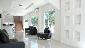 Un vaste espace de vie au design moderne, doté d’une grande fenêtre, d’un escalier et d’un décor minimaliste.