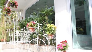 Un balcon en métal blanc orné de plantes et de fleurs en pot.