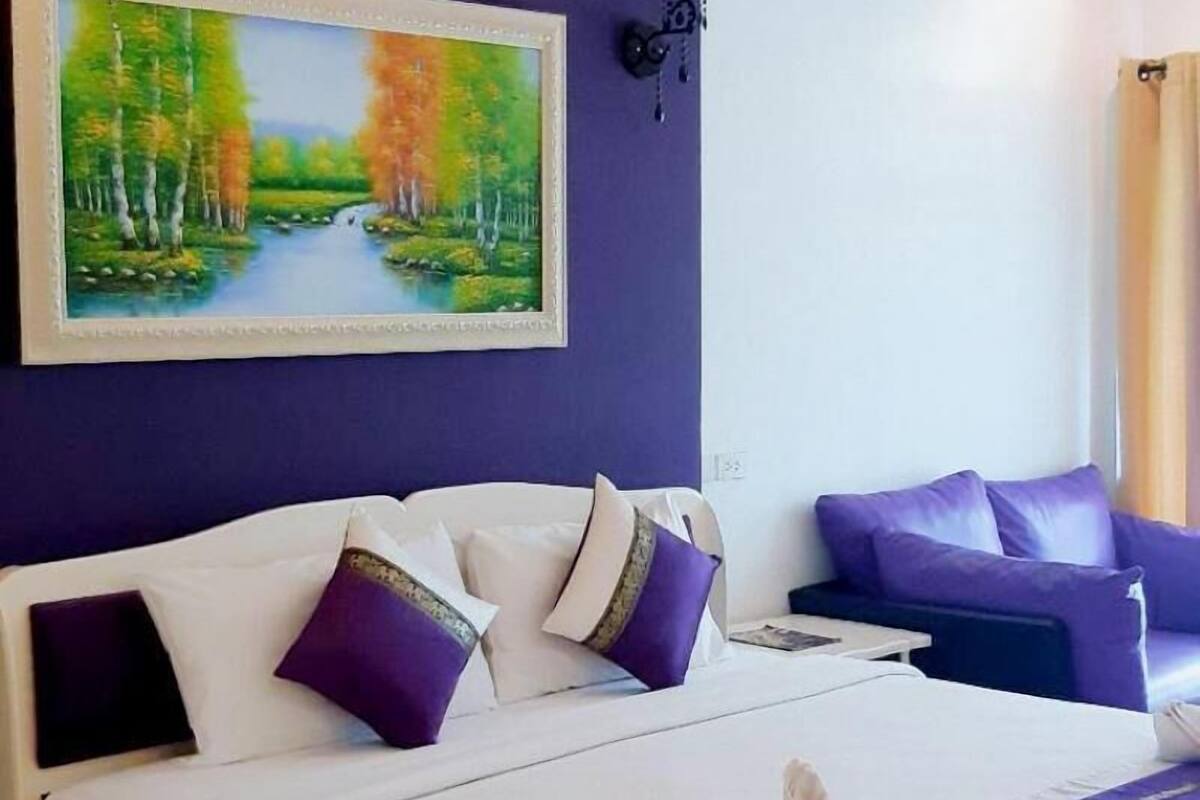 Une chambre à coucher avec un lit, un tableau et une table de chevet.