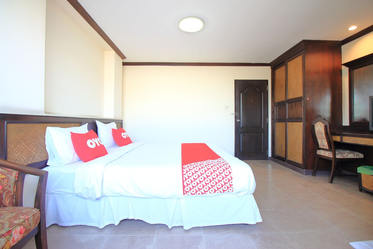 Une chambre d’hôtel avec un lit, un bureau et une chaise.