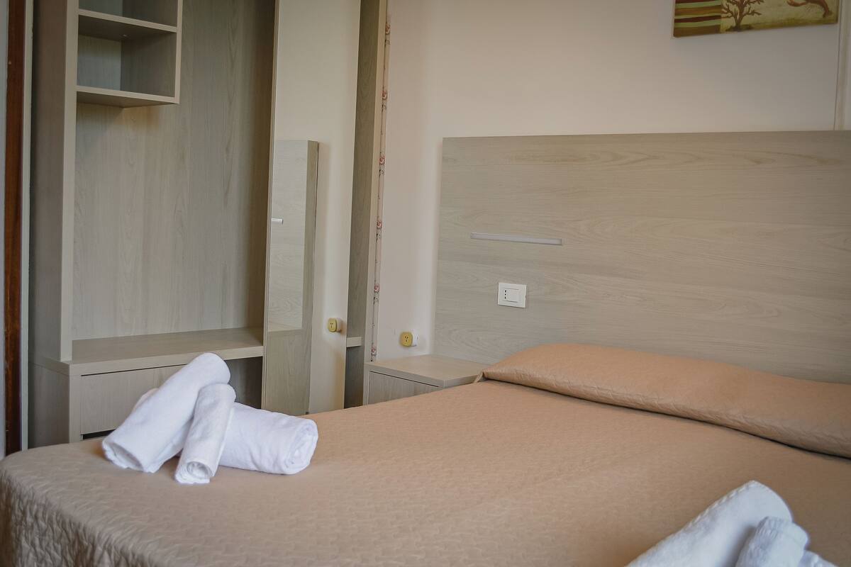 Ein Hotelzimmer mit Bett, Schrank und einer Wandablage.