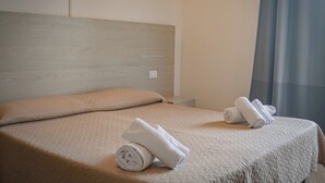 A hotel room with a bed, a headboard, and a nightstand.
