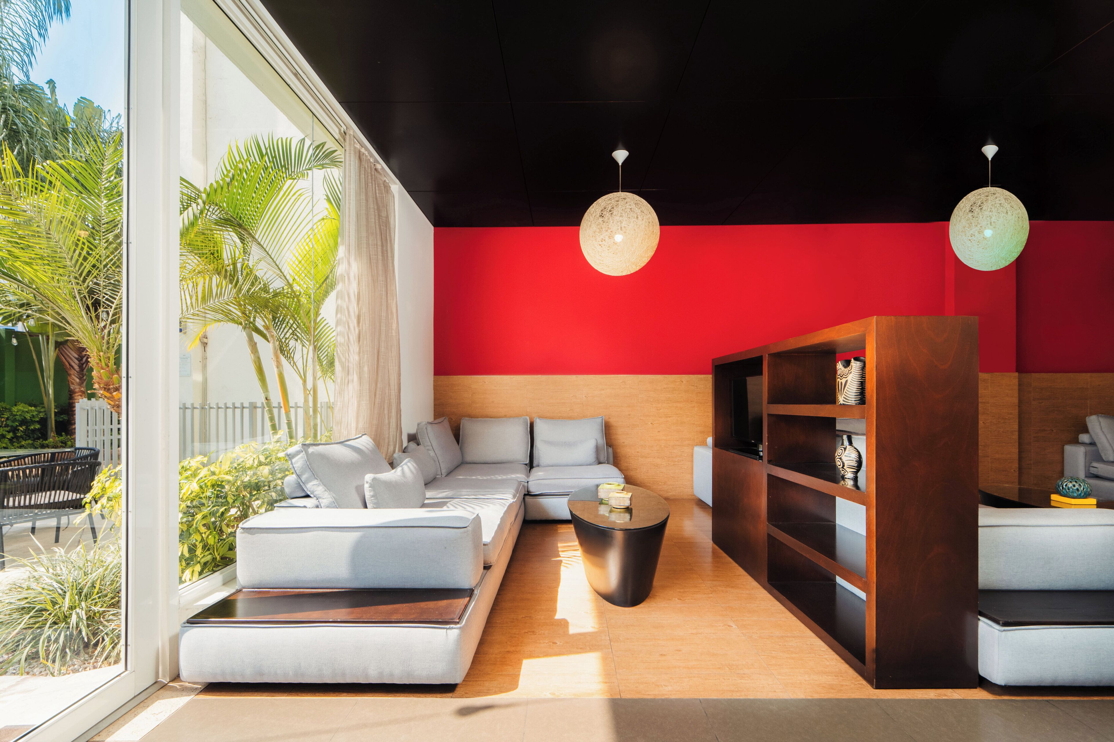 A modern living room with a sectional sofa, a coffee table, and a bookshelf.