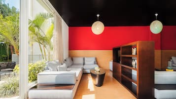 A modern living room with a sectional sofa, a coffee table, and a bookshelf.