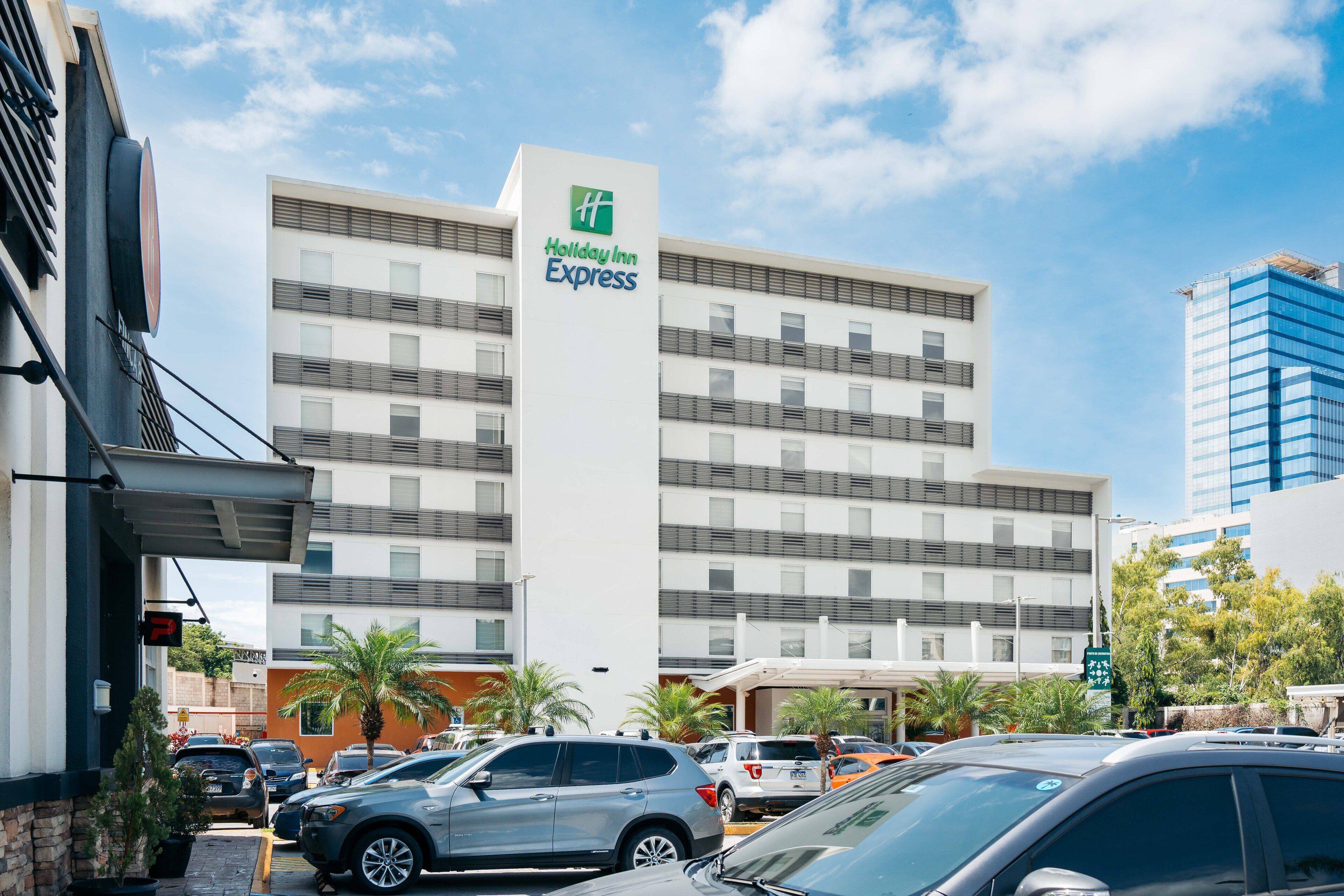 Un edificio de Holiday Inn Express con un diseño moderno, que cuenta con varios pisos y un letrero llamativo.