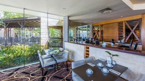 A modern restaurant with a glass enclosure, outdoor seating, and a view of greenery. - The Sebel Swan Valley The Vines (The Vines)