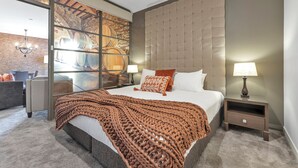 A modern bedroom with a large bed, a glass wall with a view of barrels, a tufted headboard, and a nightstand with a lamp. - The Sebel Swan Valley The Vines (The Vines)