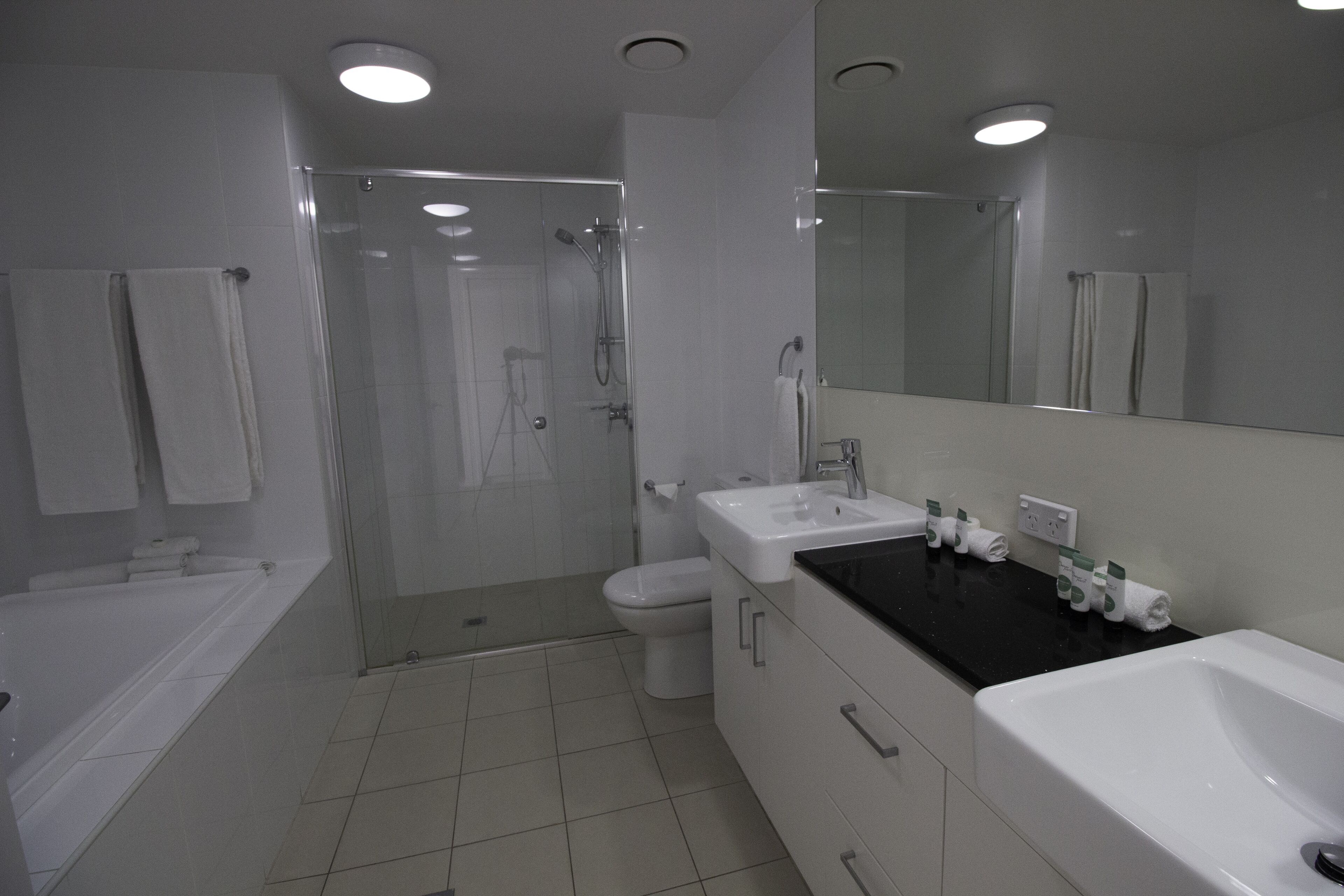 A modern bathroom with a glass-enclosed shower, a white sink, and a bathtub.