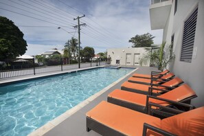 A swimming pool with lounge chairs and a clear sky. - Gladstone Central Plaza (Gladstone)