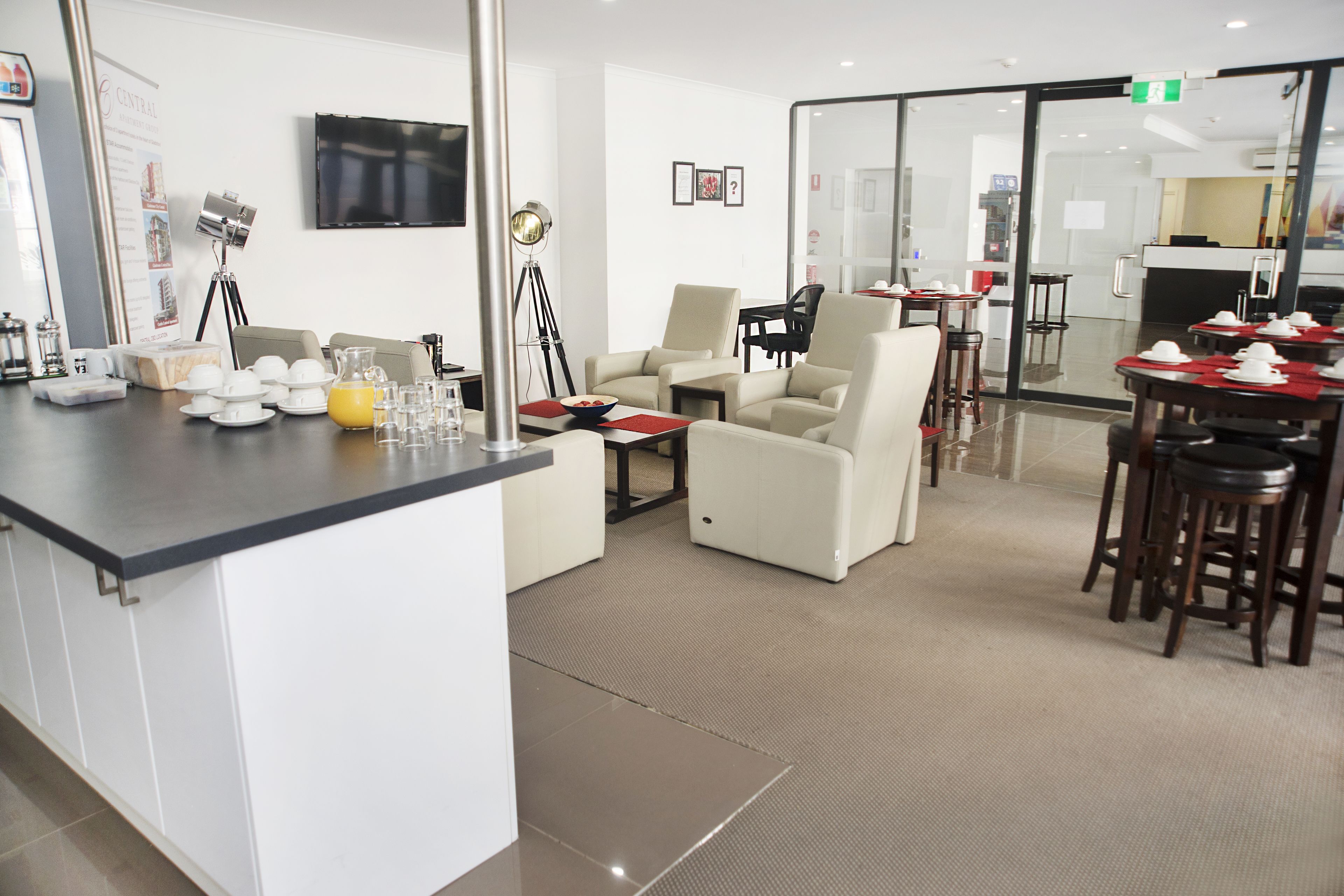 Un moderno vestíbulo de hotel con recepción, zona de estar y comedor.