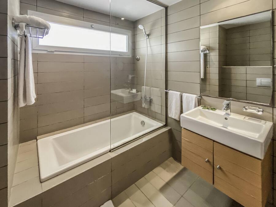 Ein modernes Badezimmer mit einer gläsernen Duschkabine, einer freistehenden Badewanne und einem Waschtisch.