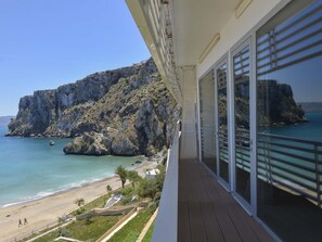 Un balcón con vistas a la costa rocosa y la playa.