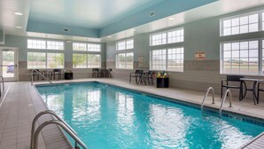 An indoor swimming pool with clear blue water, surrounded by windows and chairs. - Best Western Plus Patterson Park Inn (Arkansas City)