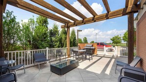 An outdoor patio with a pergola, seating area, and a barbecue grill. - Best Western Plus Patterson Park Inn (Arkansas City)