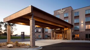 A Country Inn & Suites building with a covered entrance, brick facade, and multiple windows. - Country Inn & Suites by Radisson Roseville - St. Paul (Roseville)