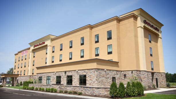 A multi-story hotel with a stone facade, multiple windows, and a clear sky.