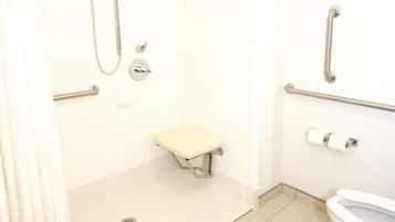 A bathroom with a shower, toilet, and grab bars.