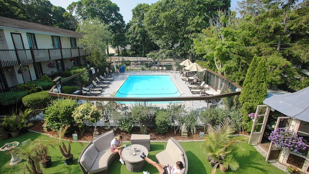 Un espace extérieur avec une piscine, des chaises longues et un coin salon abrité.