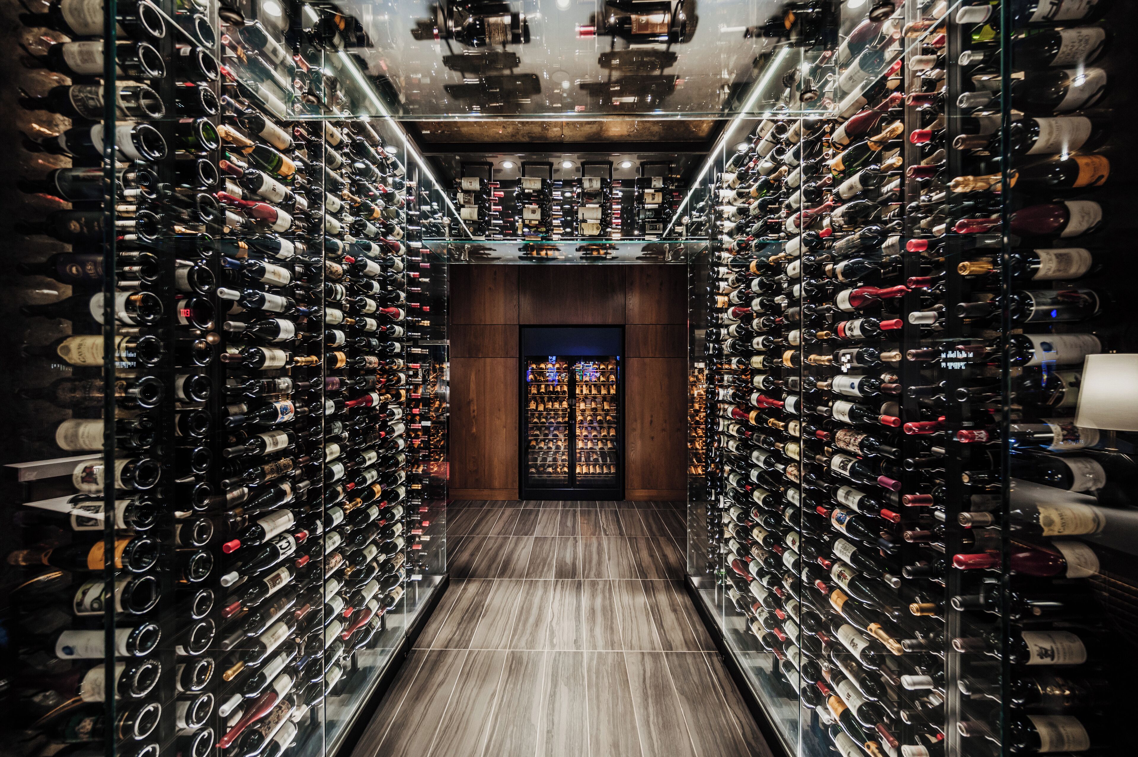 Una bodega con hileras de botellas de vino en estantes.