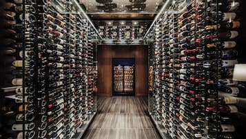 Una bodega con hileras de botellas de vino en estantes.