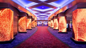 A corridor with a red carpet, illuminated walls, and a ceiling with blue lighting.