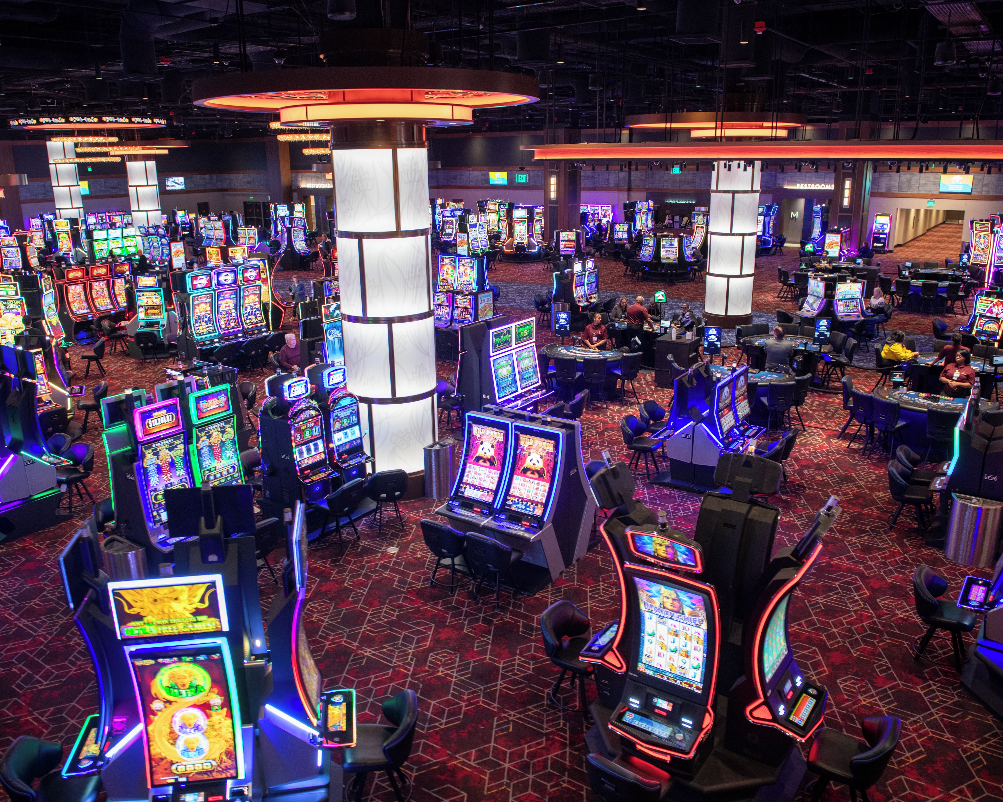 A casino floor with multiple gaming tables and slot machines.