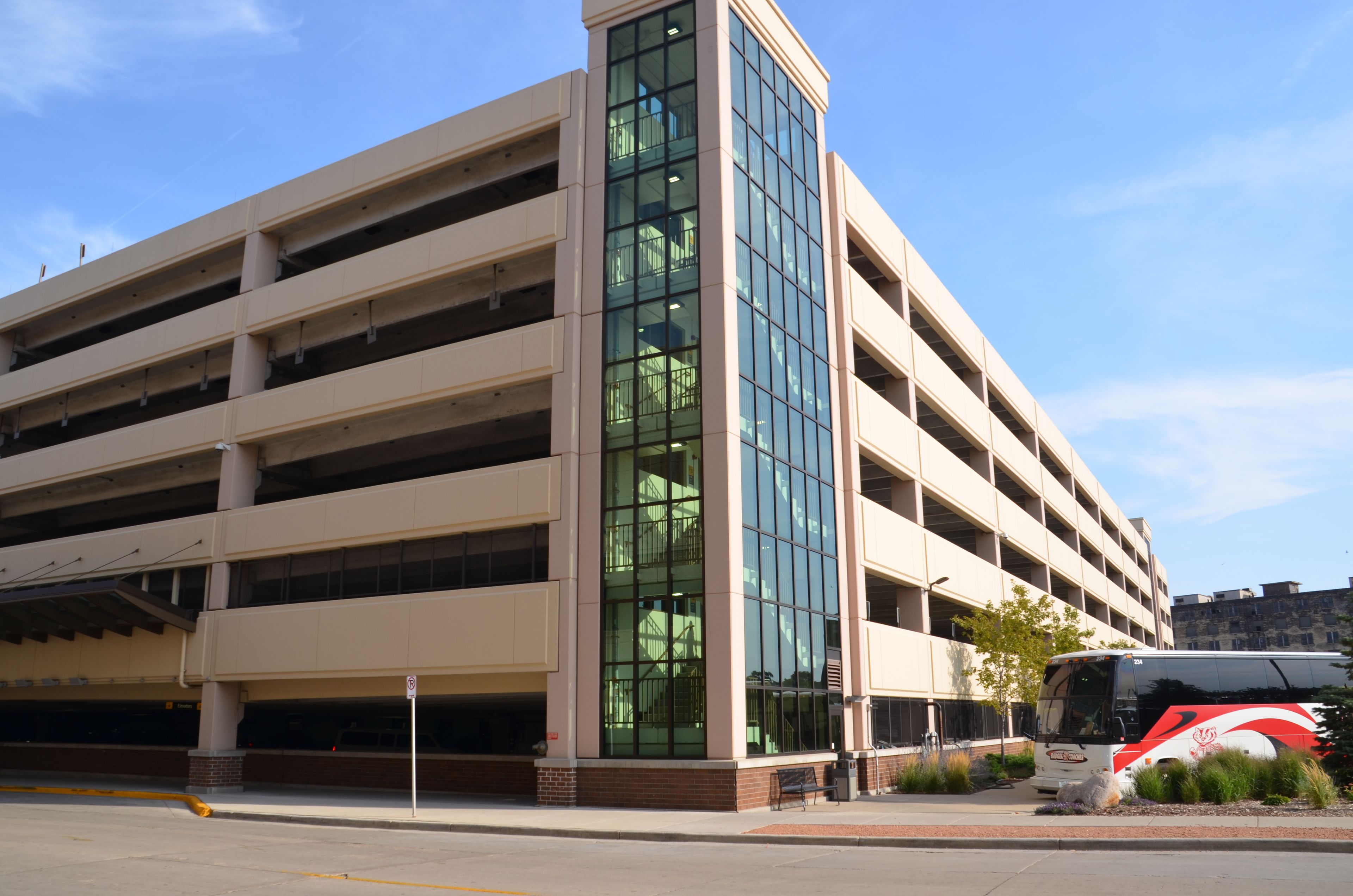 A multi-story parking garage with a modern design, featuring large glass windows and a flat roof.