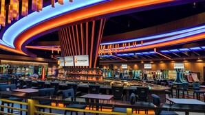 A modern bar area with multiple gaming machines and seating arrangements.