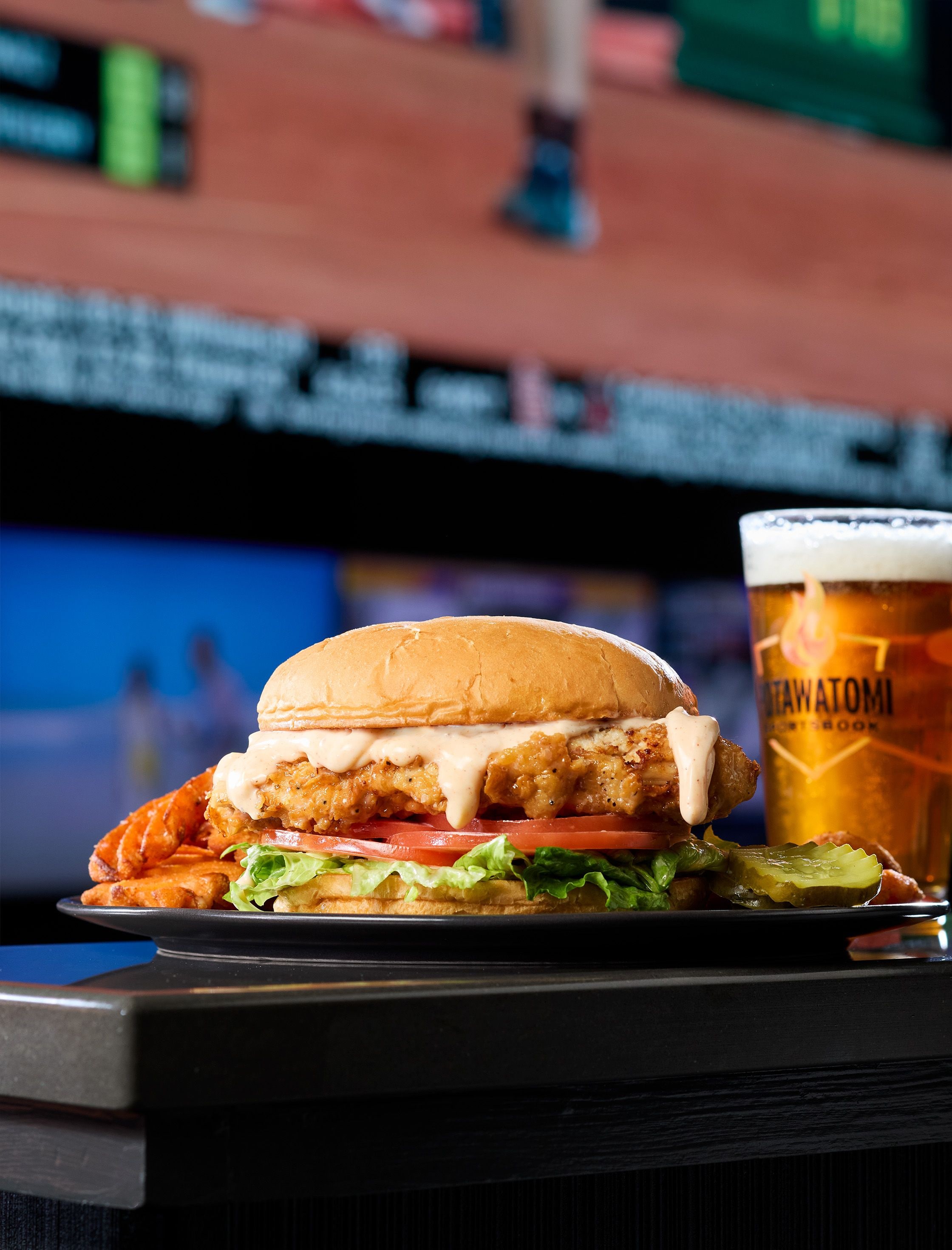 A meal consisting of a sandwich and a glass of beer on a table.