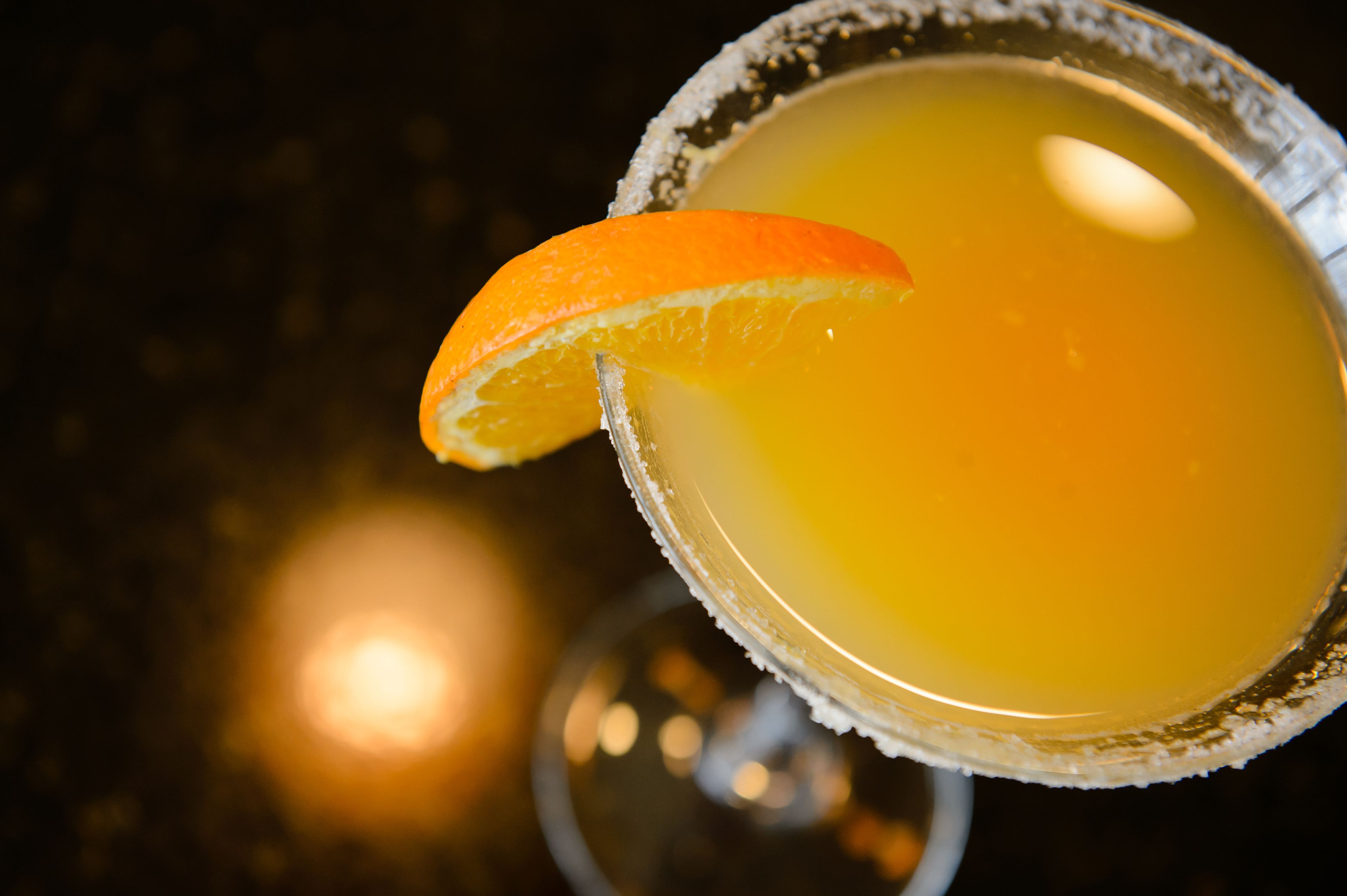 Un got de margarita amb vora de sal i una garnitura d'aranja.