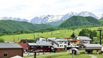 Un pittoresco villaggio rurale con case, un piccolo edificio e montagne sullo sfondo.