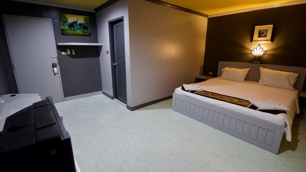 A hotel room with a bed, bedside table, and a desk. - The Little Moon Residence (Patong)