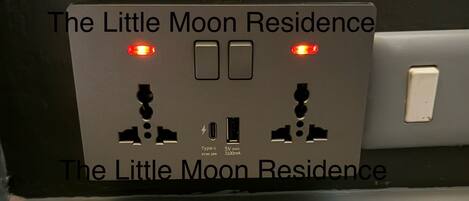 Eine Steckdose mit zwei Schaltern und zwei Kontrollleuchten, beschriftet mit „The Little Moon Residence“.