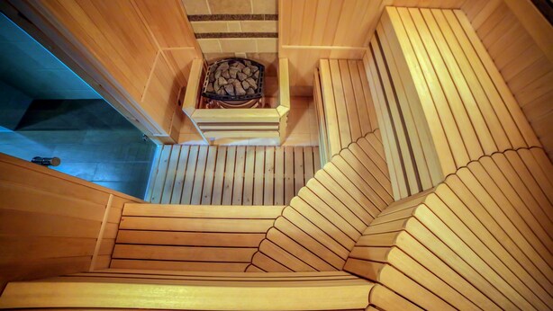 A wooden staircase with a fireplace at the top. - City Hotel Bishkek (Bishkek)