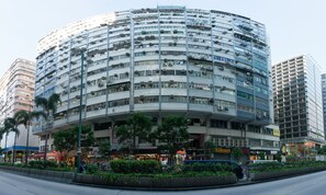 Un edificio a più piani con facciata curva, caratterizzato da numerosi balconi e condizionatori.