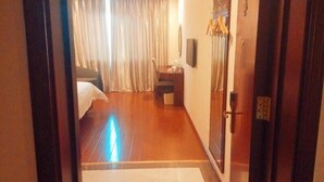 A hotel room with a bed, a desk, a chair, and a television on the wall. - GreenTree Inn Beijing East Yizhuang District Second Kechuang Street Express Hotel (Beijing)