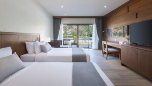 Quarto de hotel moderno com duas camas, uma escrivaninha, televisão e vista para o exterior.
