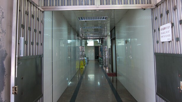 A corridor with a sign reading "金通大厦" and a sign prohibiting iron wheels. - Hao's Inn (Kowloon)