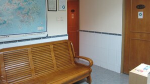 A wooden bench, a map on the wall, and a door with a sign. - Hao's Inn (Kowloon)