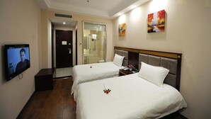 A hotel room with two beds, a TV, a shower, and artwork on the walls. - GreenTree Inn Meizhou Meijiang District Wanda Plaza Hotel (Meizhou)