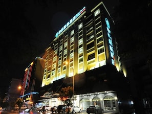 Un hotel de varios pisos con señalización iluminada y una fachada moderna.