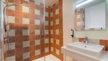 A bathroom with a shower area and a sink.