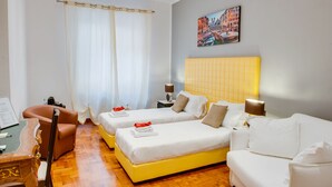 A hotel room with two beds, a sofa, a desk, and a painting on the wall. - Lh Royal Suites (Rome)